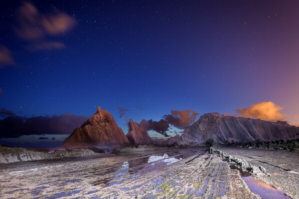 Puesta de sol sobre las rocas. cielo estrellado nocturno