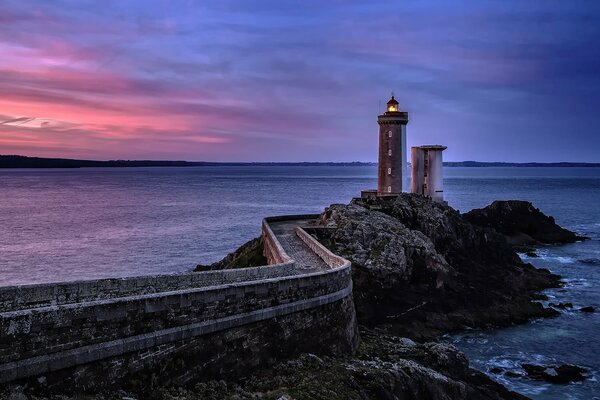 Niente di superfluo su un faro vicino al mare di Francia su una roccia durante il tramonto