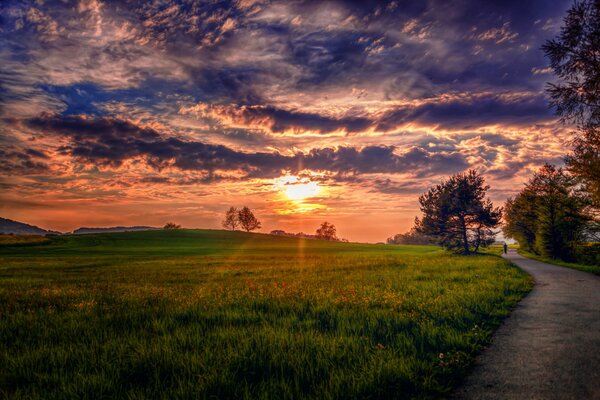 Paisaje de puesta de sol en prados junto al camino