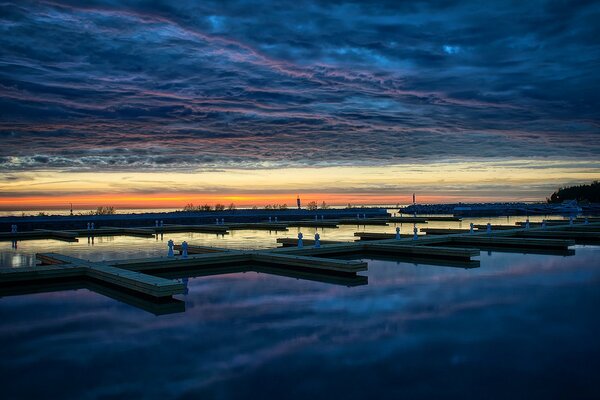 Paisaje nocturno del muelle y el sol Poniente