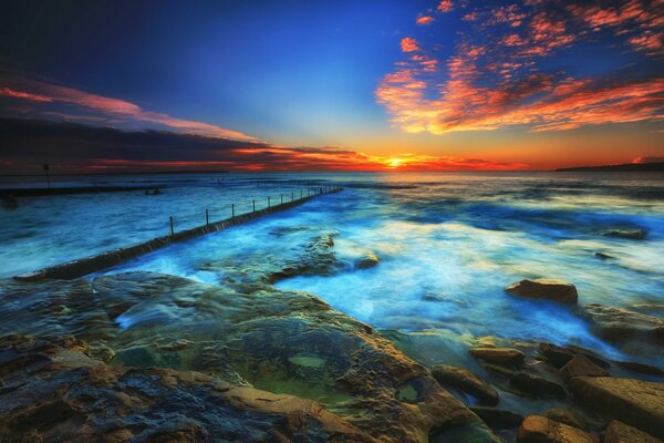 Sunset on the sea. Rocks and clouds