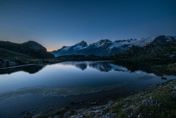 In den Bergen kann man nachts eine unglaubliche Landschaft am See finden