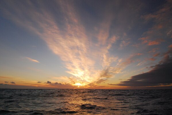 Alba in mare con nuvole galleggianti