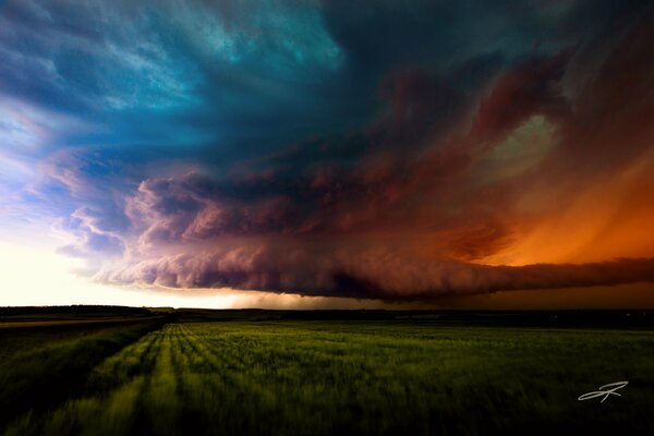 Green field and dark clouds in bad weather