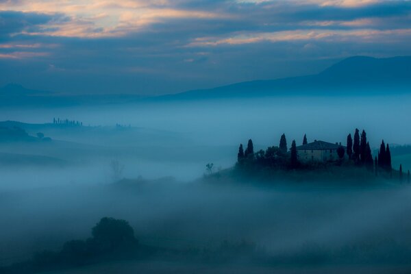 Castle landscape in fog at dawn