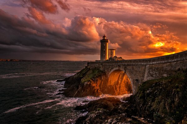 A lighthouse among the beautiful sea and mountainous terrain