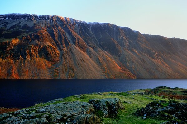 Maravillosa puesta de sol en el fondo de las montañas y el lago