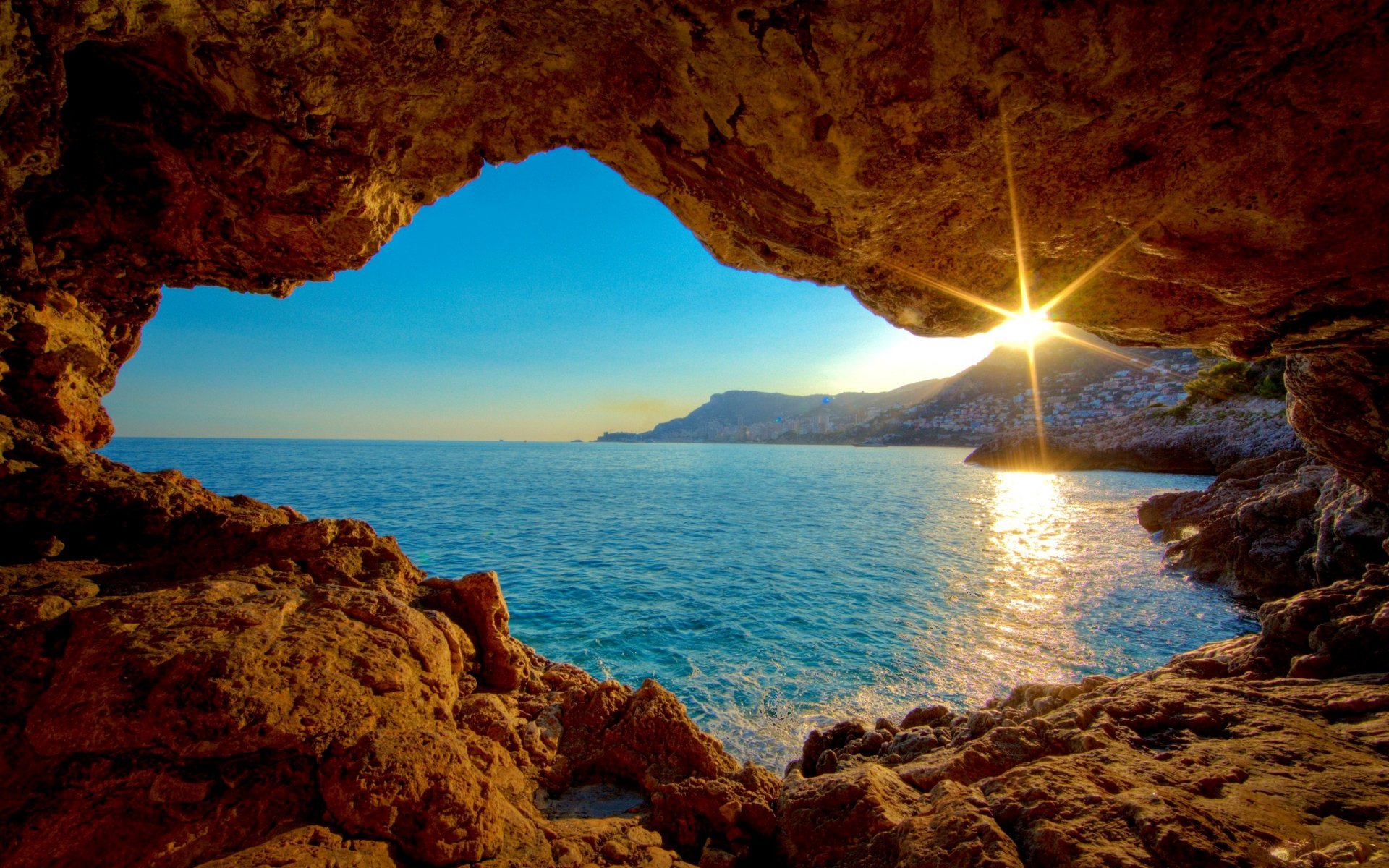 mare riva rocce grotta sole tramonto