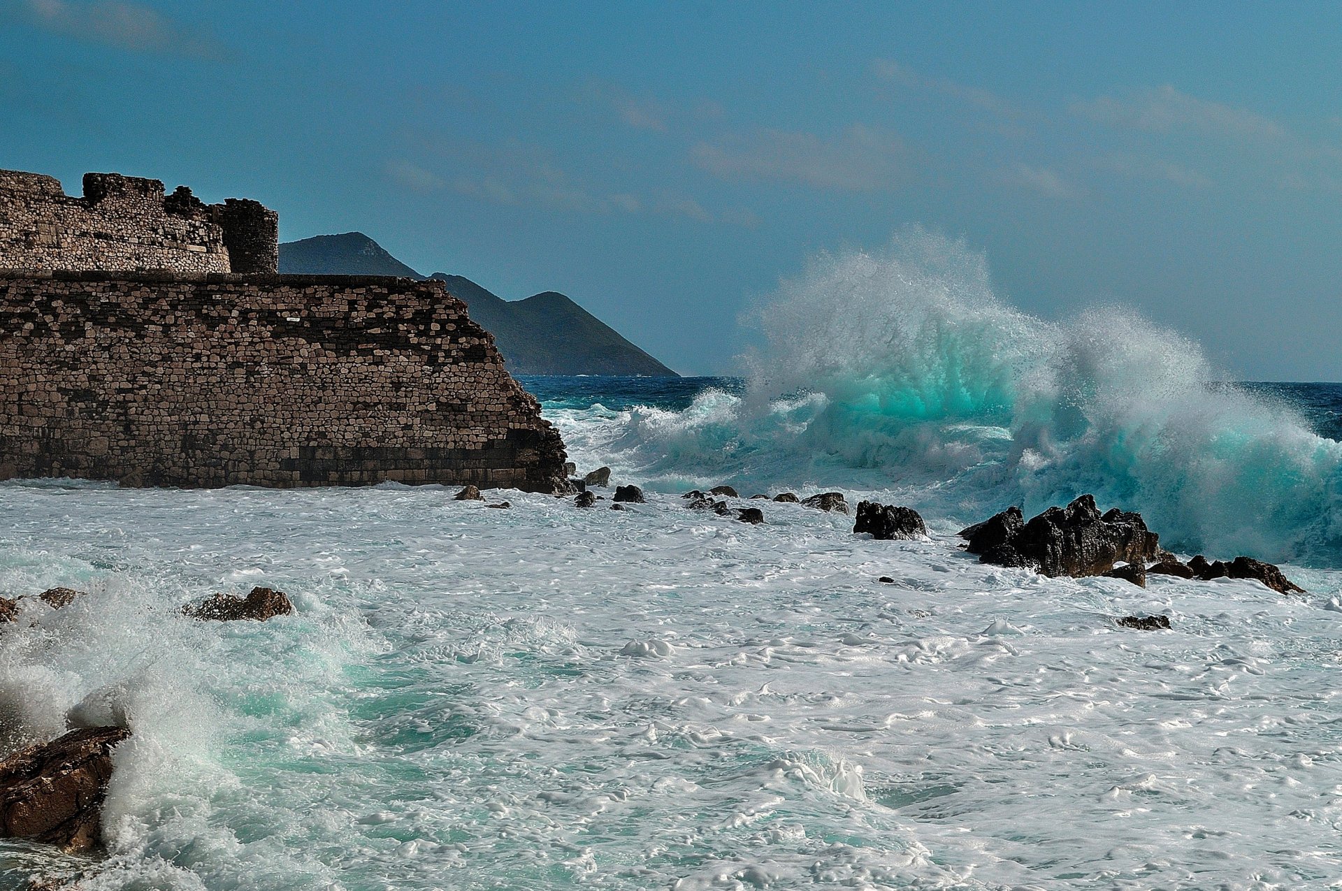 ea waves foam beach rock fort castle ruins mountain sky cloud