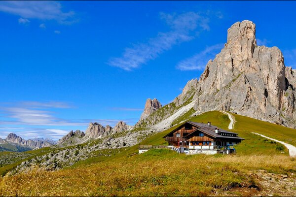 A house standing on a field near a mountain