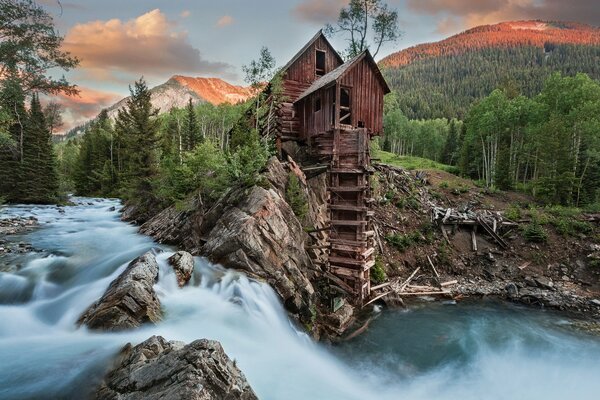 Crystal mill surrounded by deep water and forests at sunset