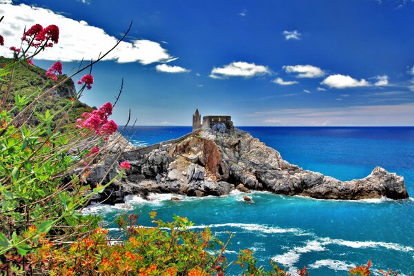 Paesaggio favoloso D Italia. Casa su una scogliera in riva al mare, importante nubi leggere galleggianti