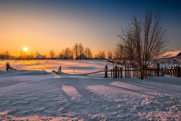 Maison dans le village au coucher du soleil conte d hiver