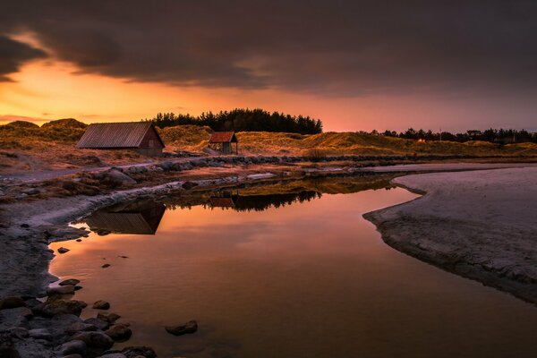 In the setting sun, a house on the river bank