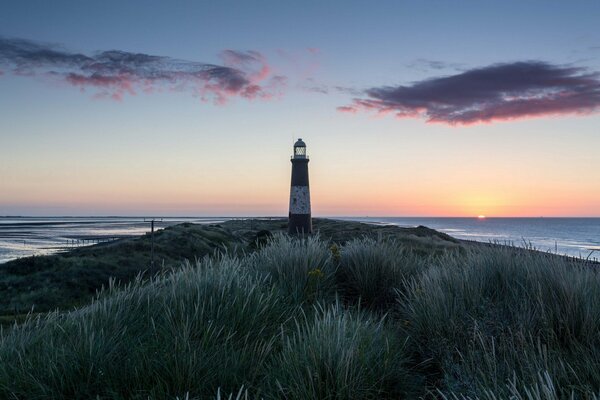 Lighthouse on the sea, at sunset