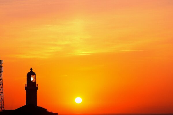 Faro en el fondo de un brillante amanecer