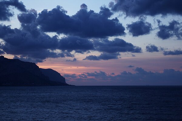 El mar Mediterráneo en Sicilia en el fondo de los acantilados de la tarde