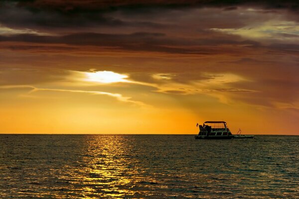 Barco en el mar en medio de la puesta de sol