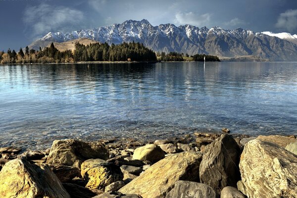 Reflexion von Bergen und Steinen im Wasser