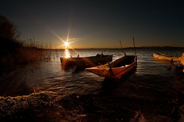Il sole illumina il lago con tre barche