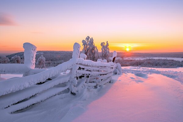 Paysage avec clôture sur fond de coucher de soleil d hiver