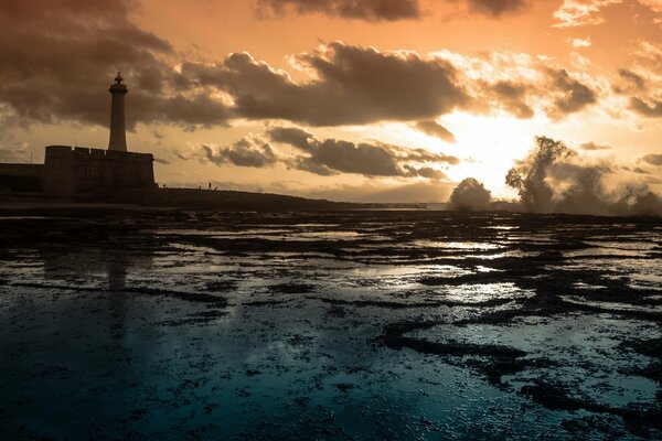 Lighthouse on the sea at sunset