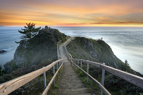 A long old wooden staircase with a railing stretches across the top of the mountain